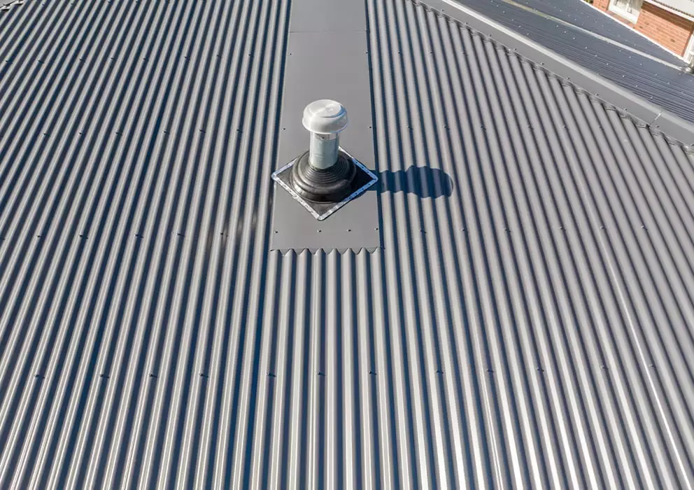 Close up of a chimney vent on a new grey long run roof.